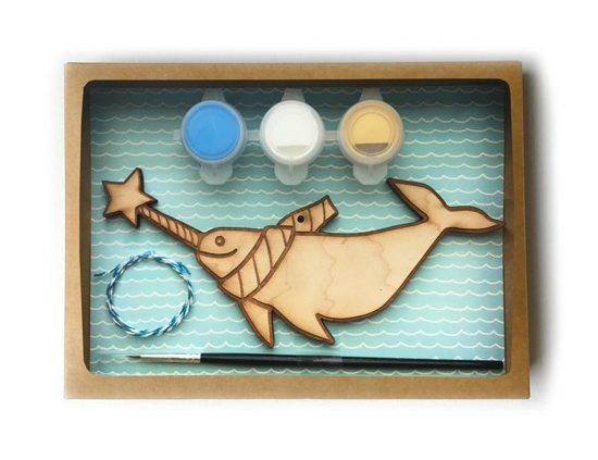 Wooden narwal paint your own ornament kit with paints and a brush.