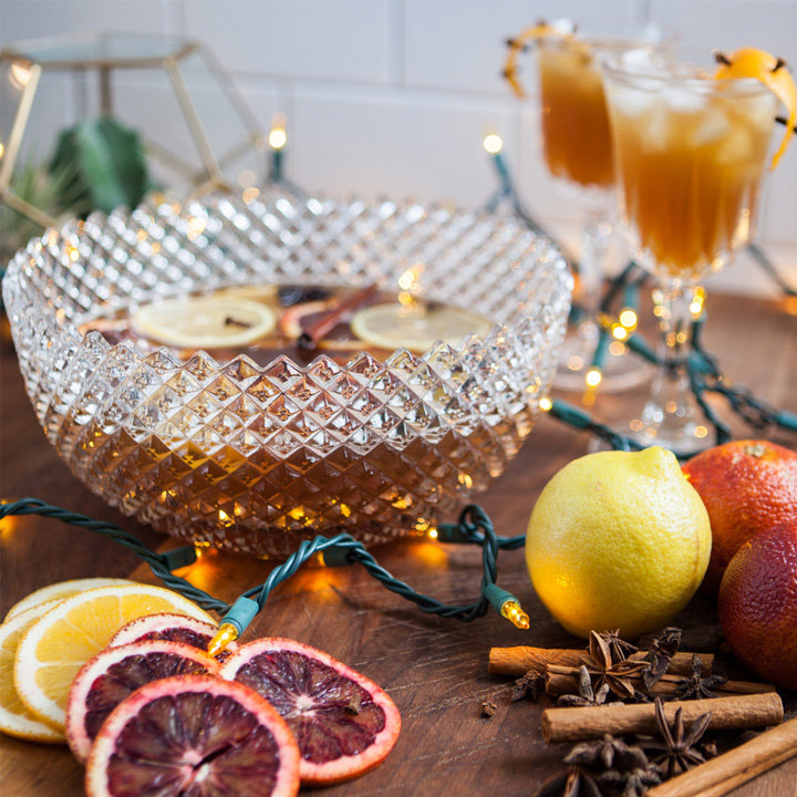 pear and pub ale party punch served in a vintage cut glass punch bowl surrounded by christmas lights