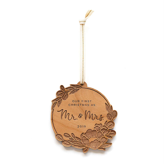 Wooden laser-cut newlywed Christmas ornament on a gold string. 