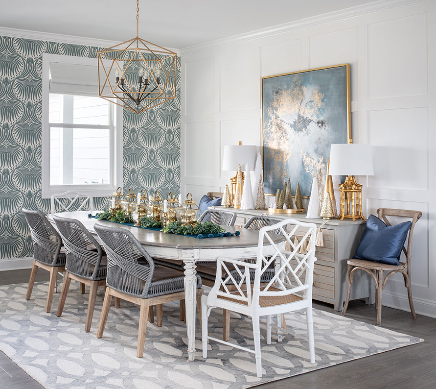 dining room with a traditional table and a mix of modern and chippendale style chairs. Blue wallpaper on one wall. 