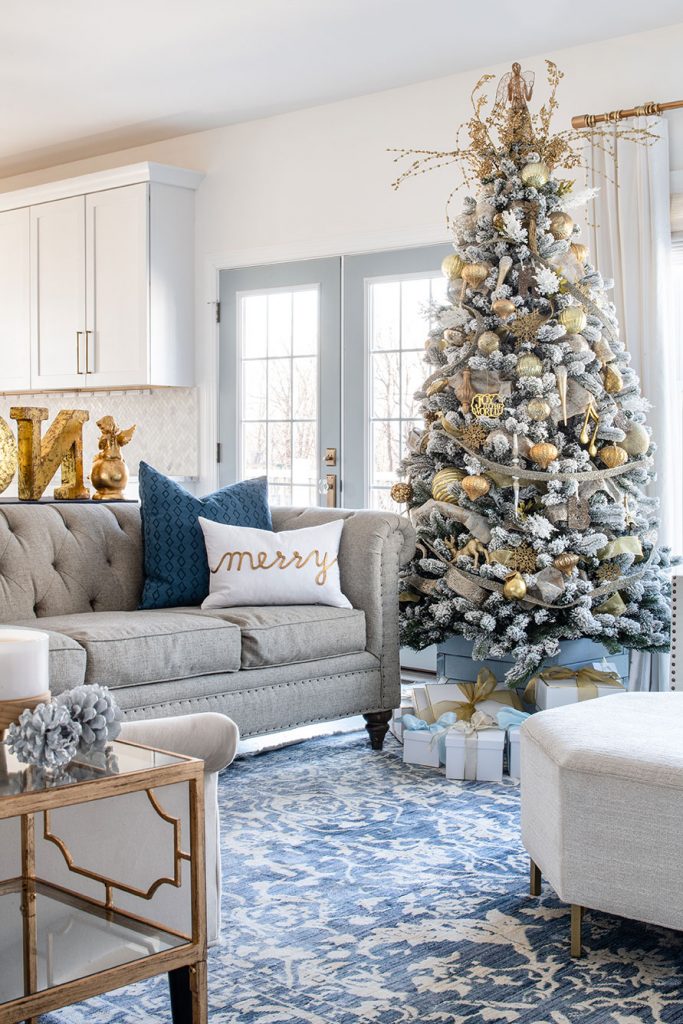 living room with flocked tree decorated in gold and white ornaments