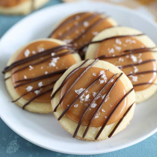 White plate with four salted caramel shortbread cookies on top. 