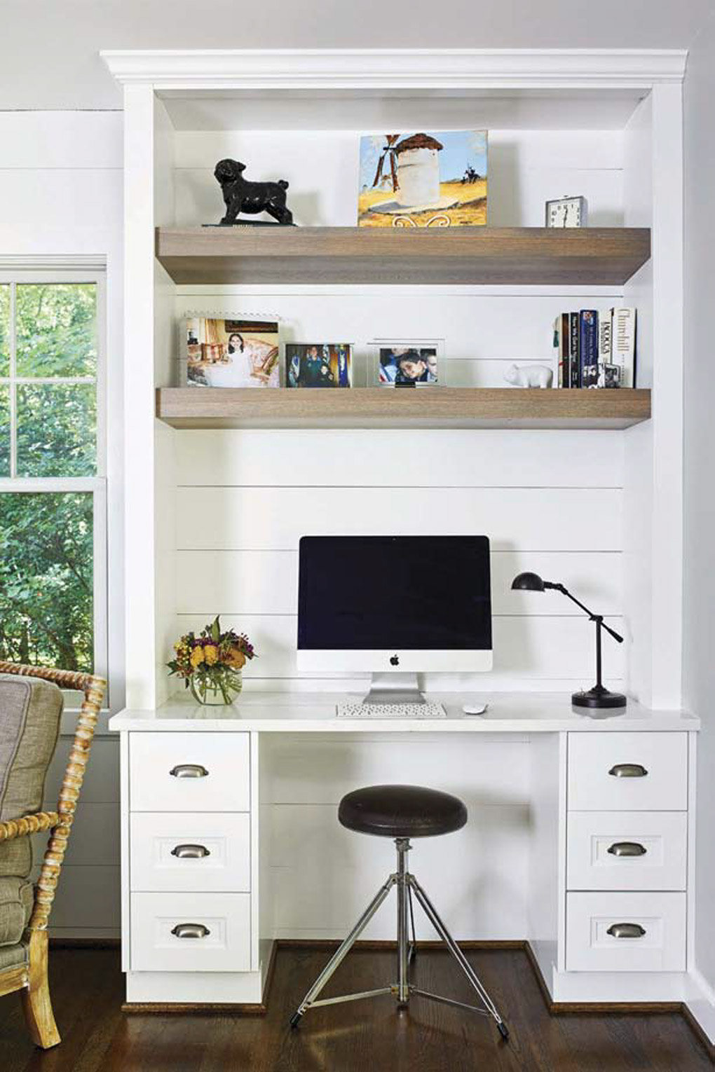 Custom white built-in with shelving, desk and small stool to sit at the computer.
