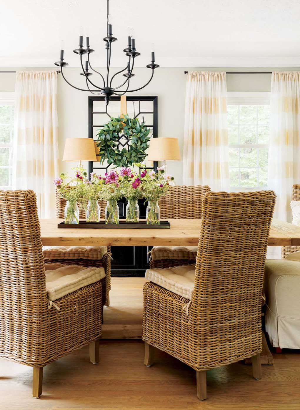 Rustic farmhouse table surrounded by a mix of woven and upholstered chairs. 