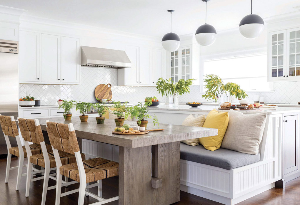 he centerpiece in this stylish, on-trend kitchen is the bench seating, which cleverly backs up to the island. Natural-looking woods and textures give a casual look to the surroundings, like the white-oak flooring in a dark stain and quartz countertops.