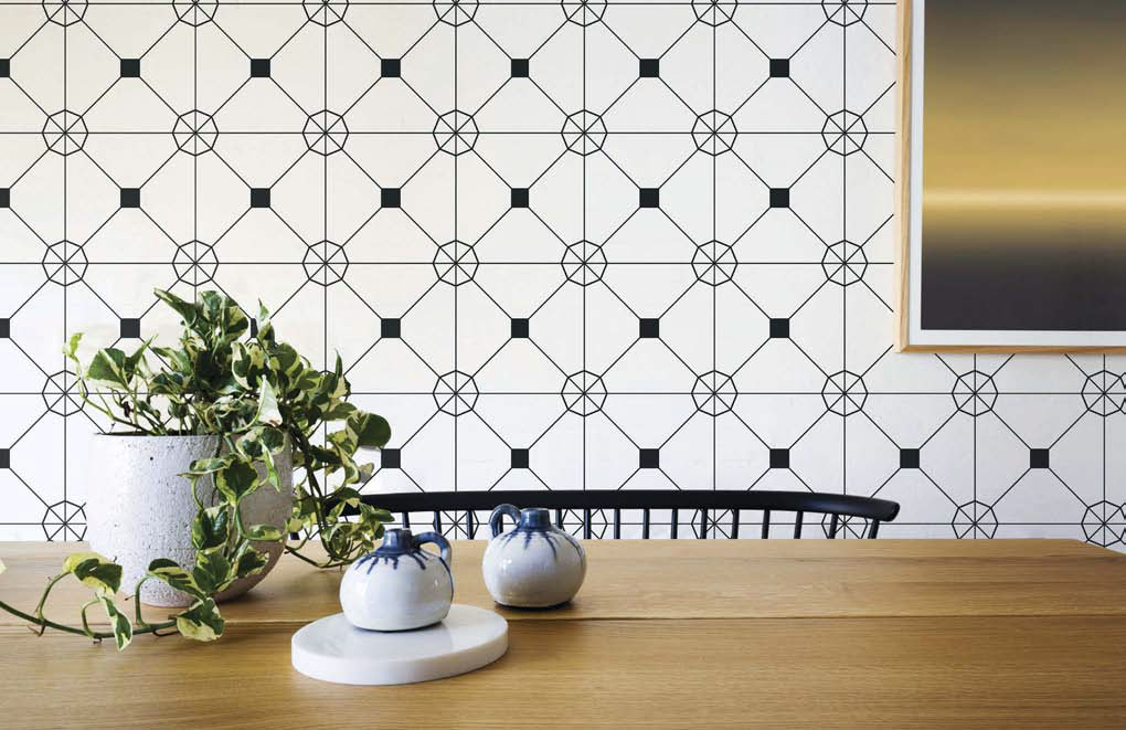 Wooden dining table with decorative salt and pepper shakers and potted plant showing off an accent wall with an intricate design of this self-adhesive wallpaper.