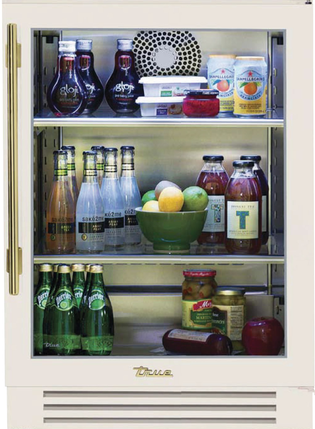 Undercounter beverage fridge in antique white with brass handle, filled with snacks and beverages.