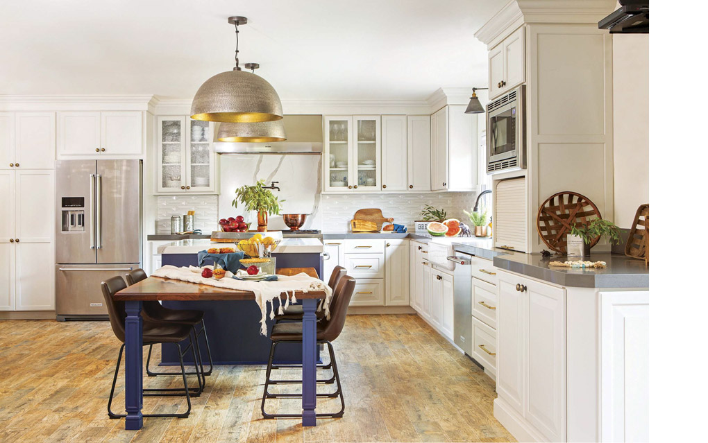 Kitchen remodel with white custom cabinets and dome pendant lights and navy blue and wooden kitchen table.