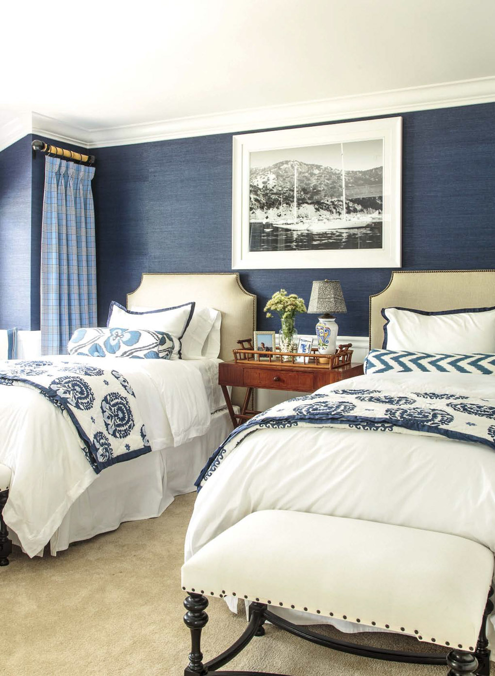 Regal British colonial style bedroom with two luxurious twin beds and blue linen textures walls. 