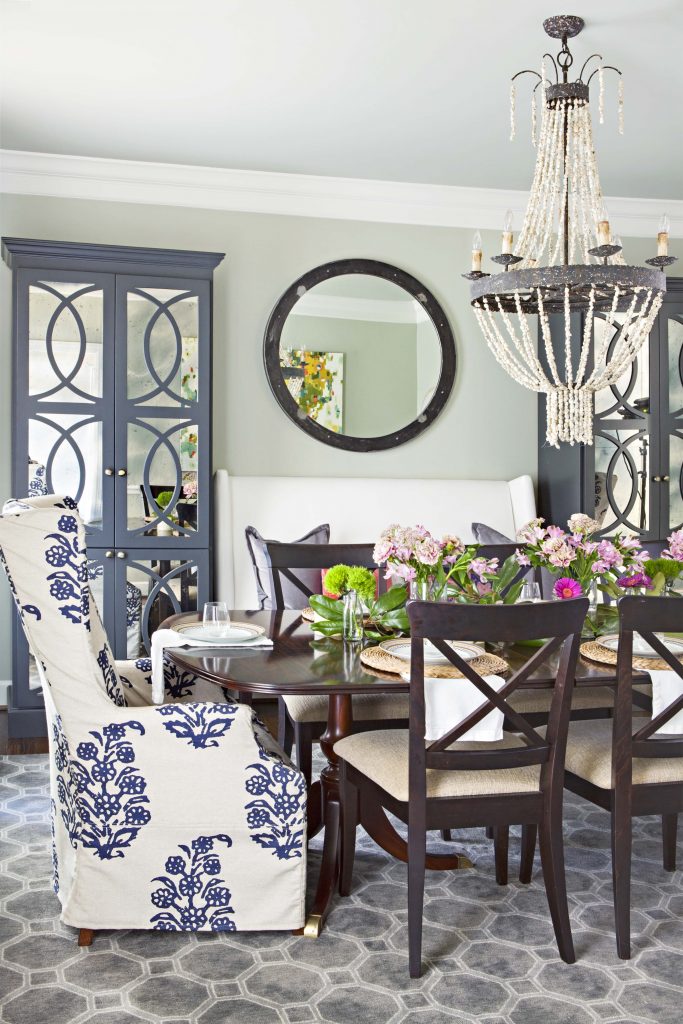 Regal cottage dining room filled with quality furniture like gray blue accents and pair of large detailed hutches in the background.