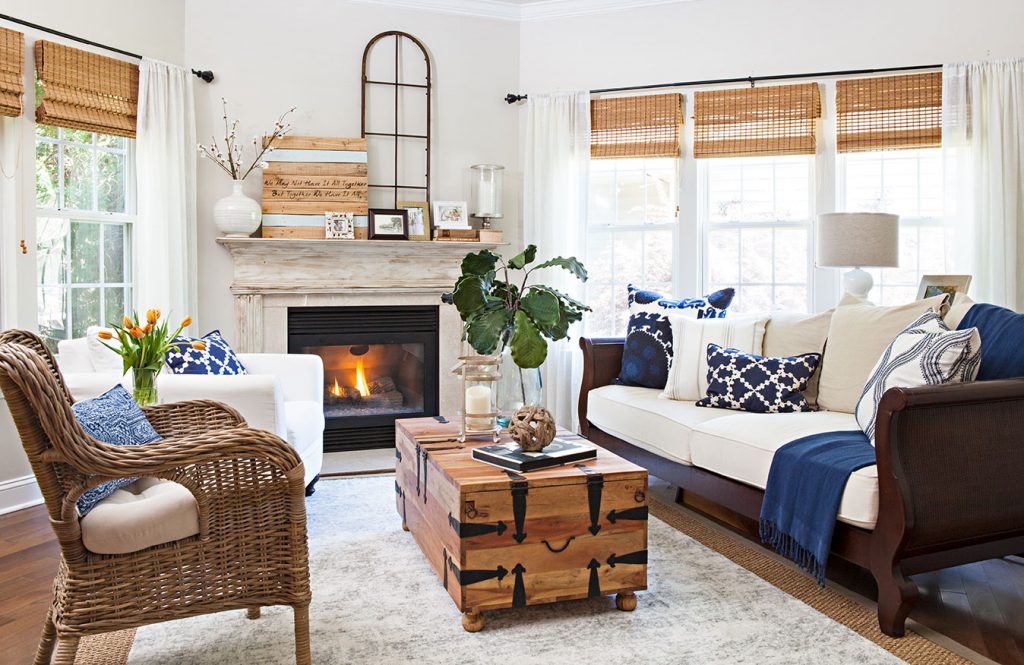 Rustic country cottage living room with whicker and wood furniture and cream and navy accents. 