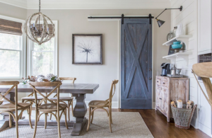 Rustic cottage kitchen with trestle table and blue sliding barn door.