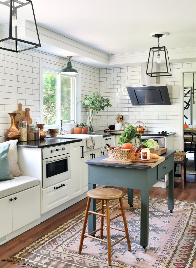 Native inspired area rug in an open concept kitchen with white cabinets and a dusty blue free standing island.