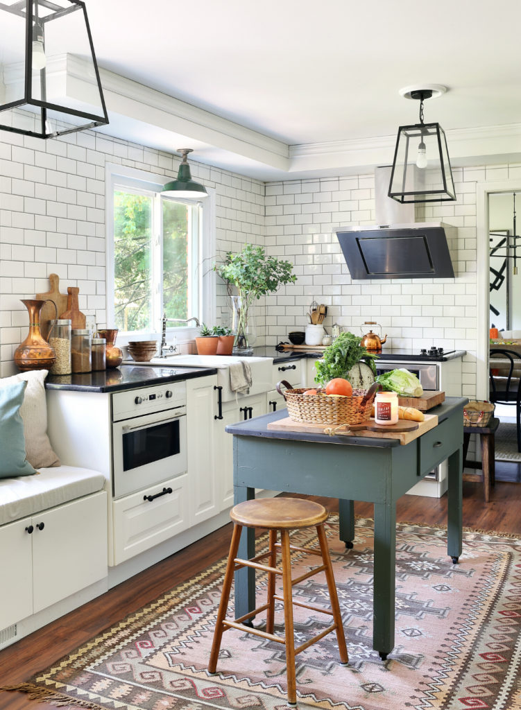 Native inspired area rug in an open concept kitchen with white cabinets and a dusty blue free standing island. 