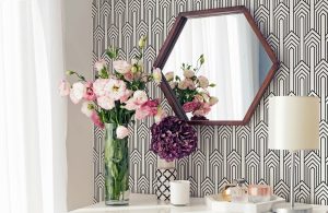 Art Deco patterned black and white wall paper in a living room with simple modern hexagon mirror at a vanity