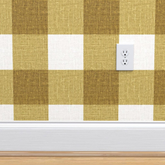 Gingham wallpaper white and mustard green color with white baseboards and white electrical outlet. 