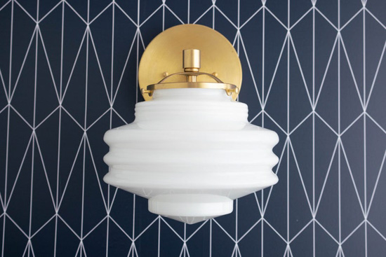 Navy and white modern wallpaper and a white and gold Art Deco styled wall lighting sconce. 