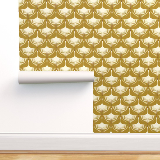 Wooden floor, white baseboards and a wallpaper panel being hung with white Art Deco swans on a gold backdrop.