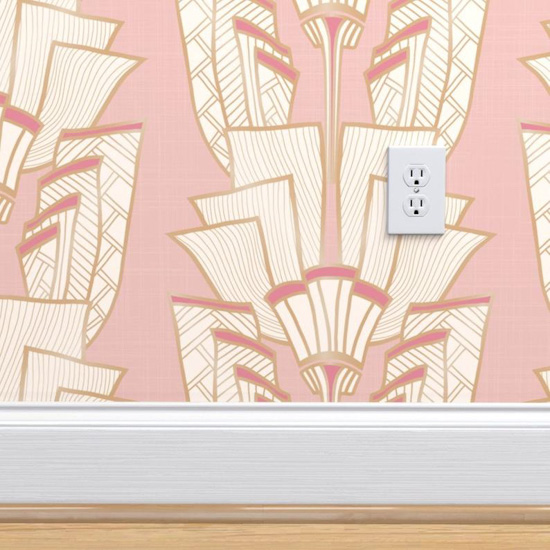 Pink Art Deco inspired wallpaper on a small patch of wall with white baseboards and a white electrical outlet. 