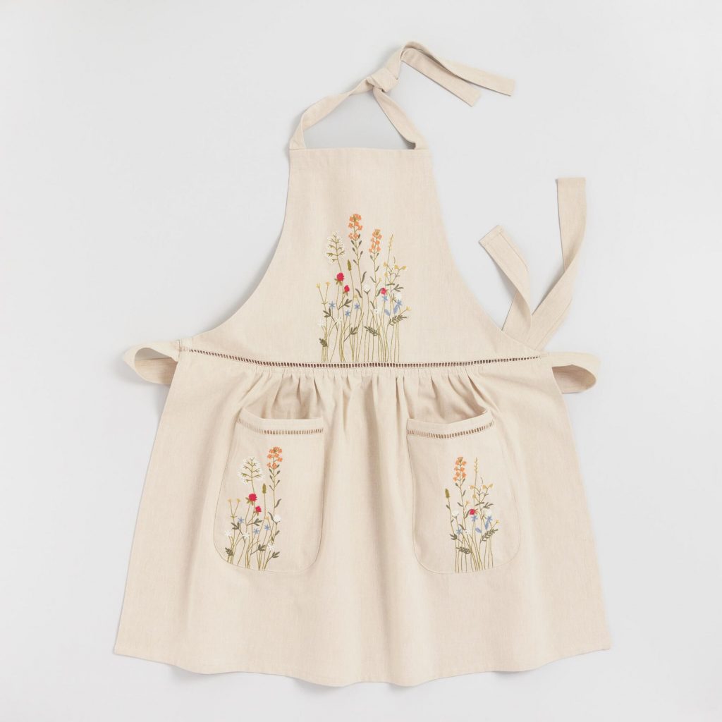 Natural cream colored embroidered floral apron with lace trim.