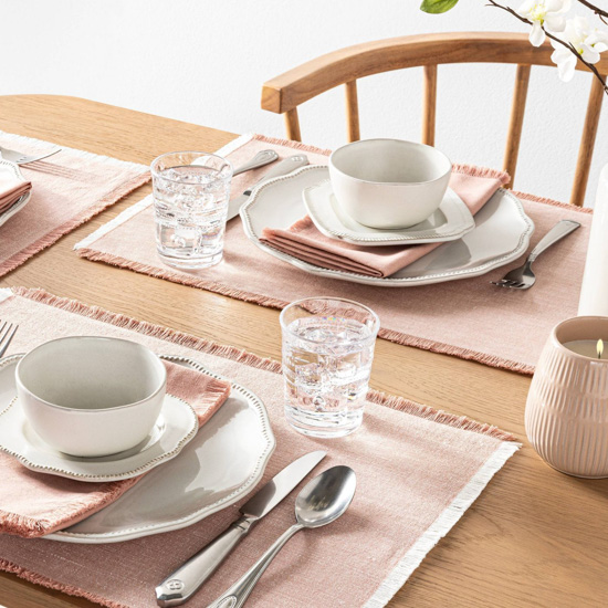 Hearth & Hand spring collection of rode gold colored placemats and napkins displayed for dining. 