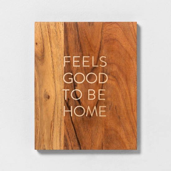 Wooden wall sign that reads, "feels good to be home." 