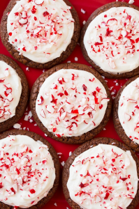 Chocolate cookies covered in white frosting and topped with crushed peppermint.