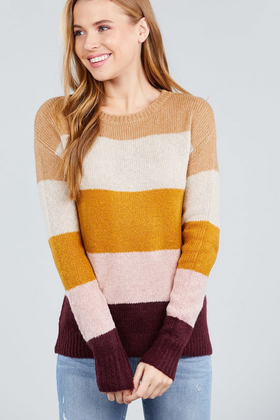 Blonde model wearing a long sleeve, color block sweater. 