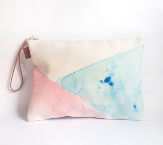 Watercolor, geometric design clutch with a brown leather wrist-strap.