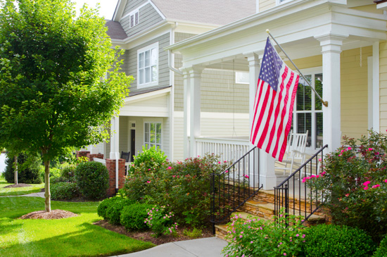 Front stoop in a pocket neighborhood with large open front porch with a prominent American flag. 