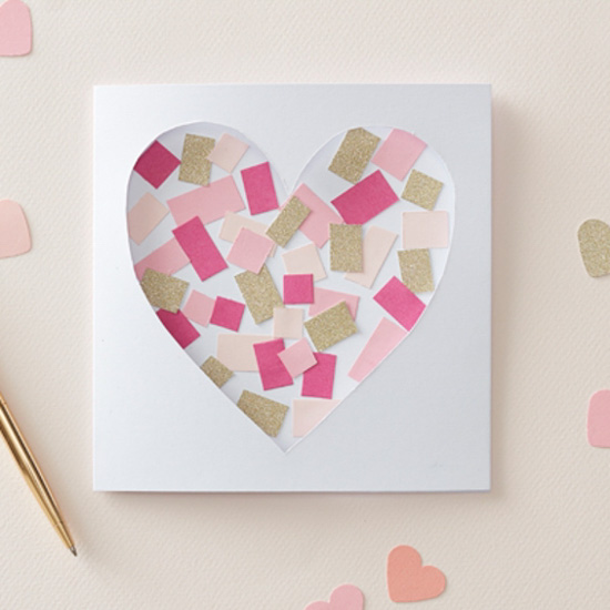 Homemade Valentine's card with a heart-shaped cutout and filled with pink and gold confetti. 