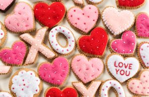 Overhead shot of Valentine's Day themed felt ornaments in the shapes of X's O's and hearts.