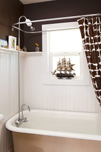 craftsman bathroom with dark brown paint on the walls and a vintage clawfoot tub