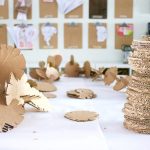 Stack-of-cardboard-building-discs-along-with-an-assembled-cardboard-sculpture-768×512