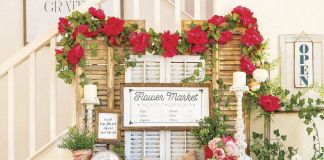 Faux flower market made up of a white dresser and shutters and a copious amount of fresh flowers.