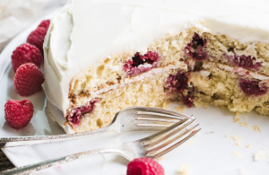 A raspberry lemon cake displayed with forks at the ready.