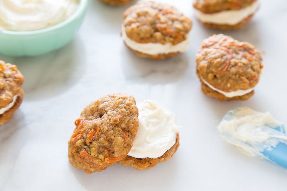 Mini carrot cake cookies sandwiched together with cream cheese frosting.