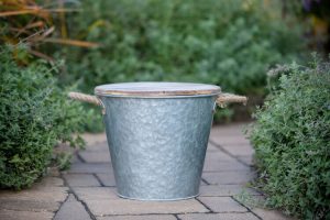 Bucket candle on patio essentials with galvanized metal