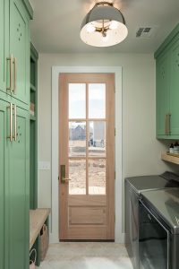 laundry and mudroom designed by Rachel Shingleton. Soft green cabinets are complimented by brass hardware