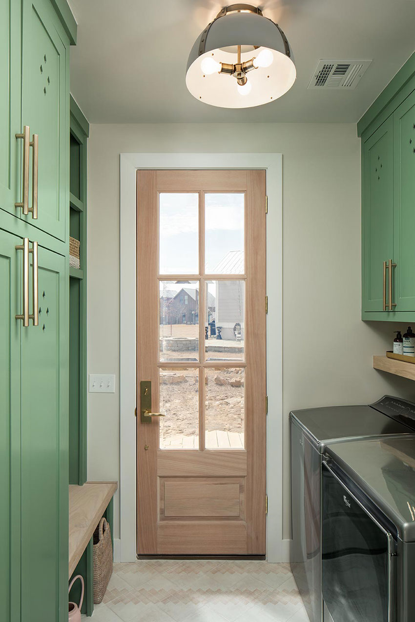 laundry and mudroom designed by Rachel Shingleton. Soft green cabinets are complimented by brass hardware