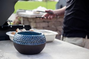 Blue ceramic pot with candle inside on tabletop