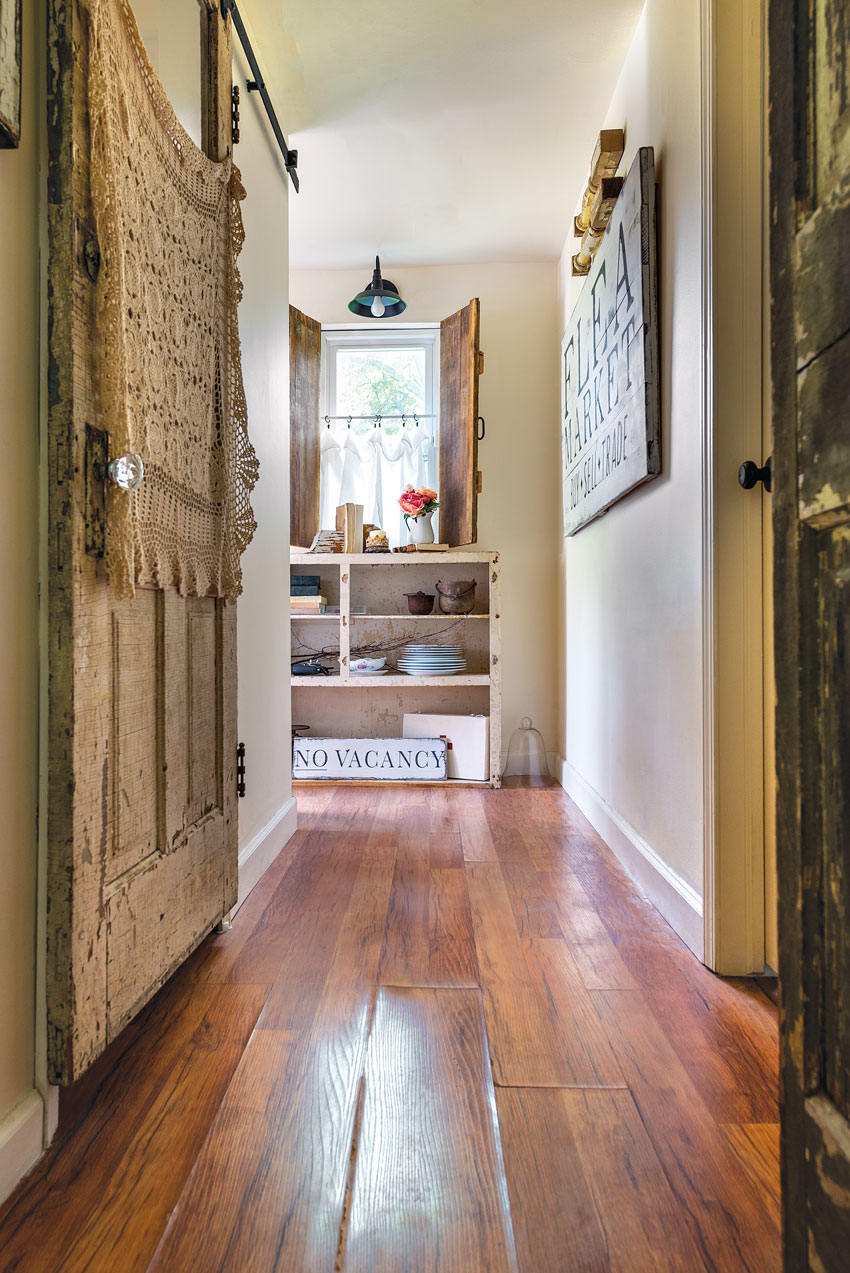 These interior of a cozy country cottage shutters that Mickie’s husband built from salvaged wood are a fun twist on the traditionally exterior window 