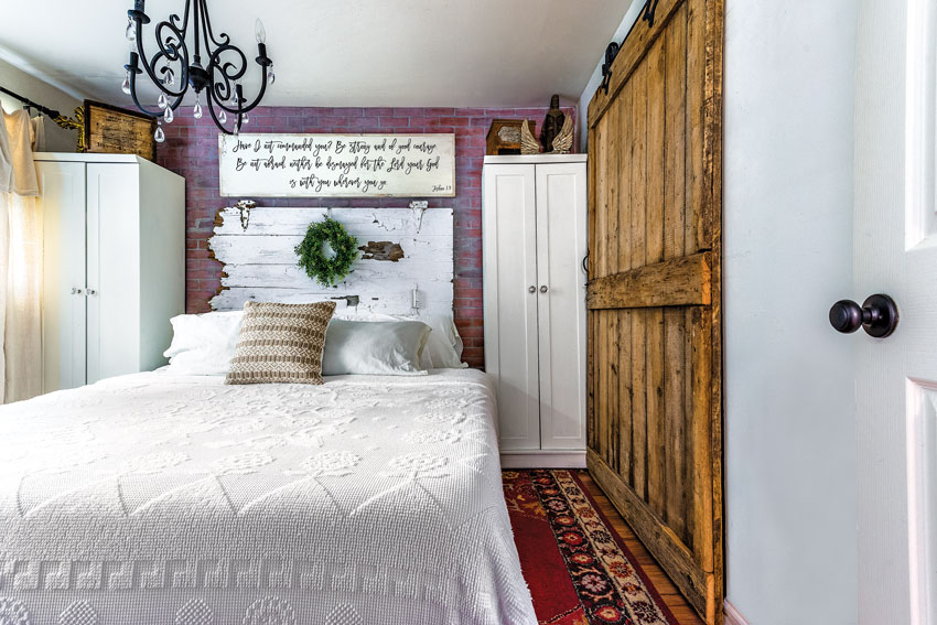 master bedroom of the cozy country cottagewith a vintage gate serves as the headboard