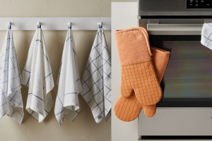 tea towels hanging on a rack and orange oven mitts hanging on an oven