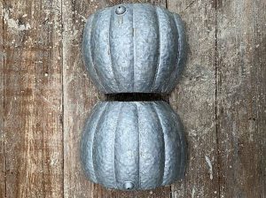 Metal pumpkin-shaped bucket is cut in half.