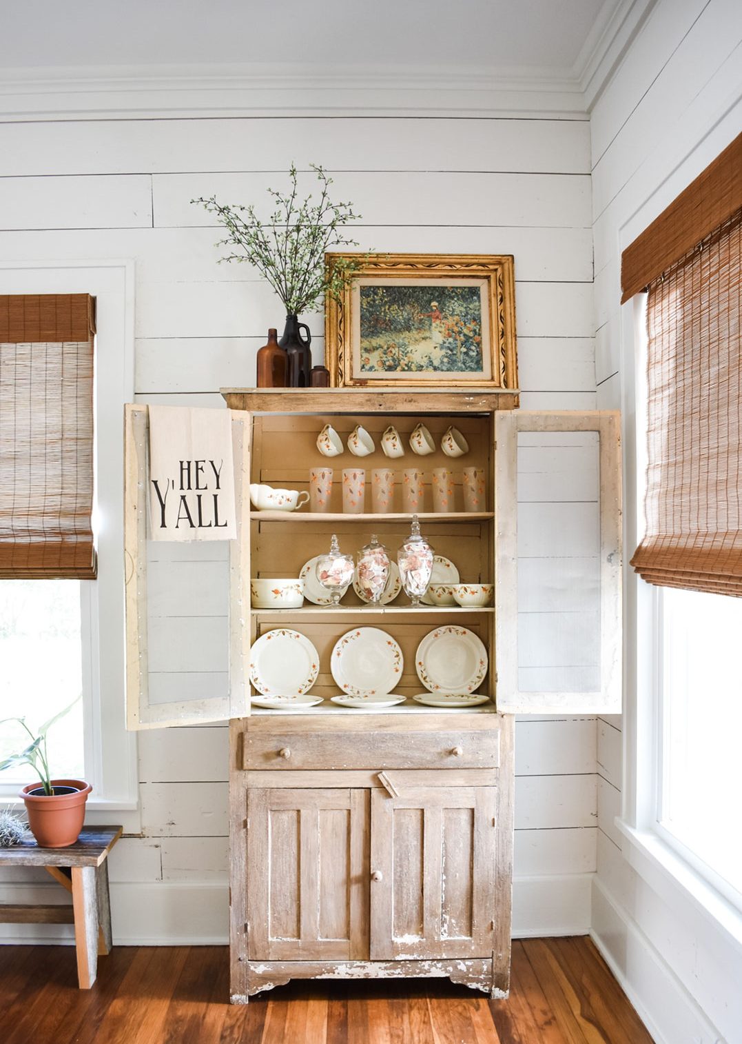 Hutch with fall china inside and apothecary jars filled with broken plate craft 