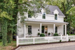 White cottage-style home exterior with white picket fence