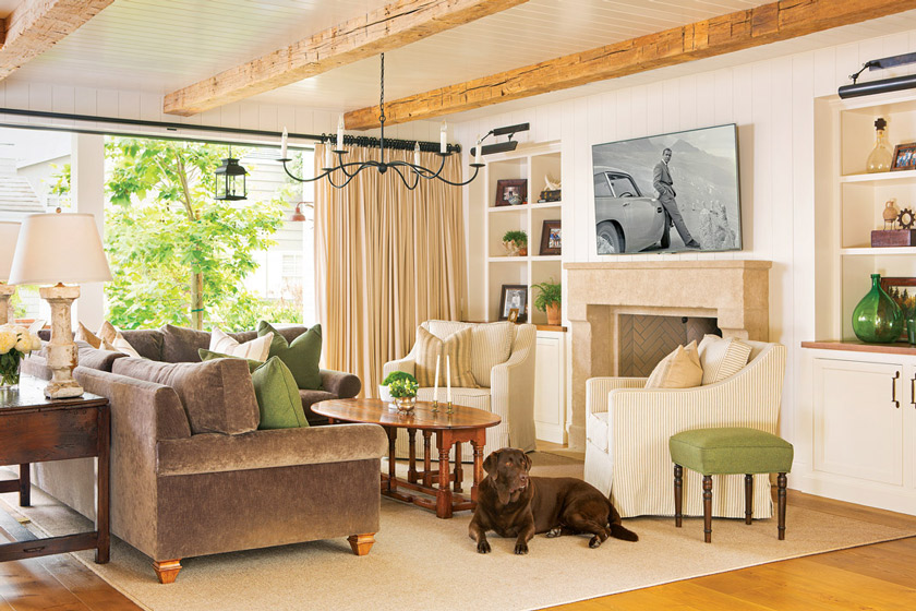 A dreamy living space, the custom limestone fireplace, vintage wood beams and individually planked shiplap capture the true essence of a European farmhouse.