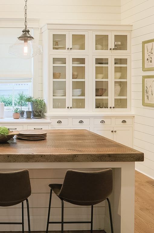 Creamy white walls and cabinets bring a vintage vibe to this interior. 