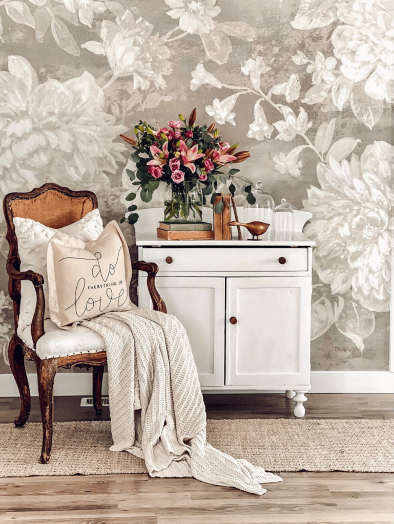 One of Rosana Milam's hand embroidered pillows sits on a chair next to a cabinet